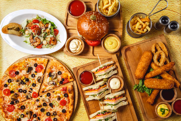 ከፍተኛ እይታ ፈጣን ምግብ ድብልቅ ሞዛሬላ እንጨቶች ክለብ ሳንድዊች ሃምበርገር እንጉዳይ ፒዛ ቄሳር ሽሪምፕ ሰላጣ የፈረንሳይ ጥብስ ኬትችፕ ማዮ አይብ ሾርባዎች ጠረጴዛ 141793 3998